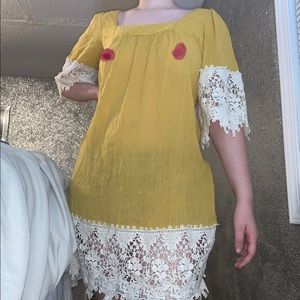 Sheer yellow dress with doily-like trim.